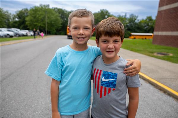 two students with their arms around each others shoulders